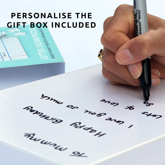 Hand writing on plain gift box of Pikkii's personalised letter jigsaw puzzle gift with permanent market
