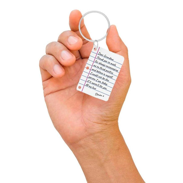 Hand holding Pikkii's personalised Little Letter Keychain over white background