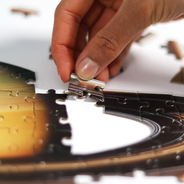 Hand piecing together Saturn puzzle in planets jigsaw puzzle by Pikkii