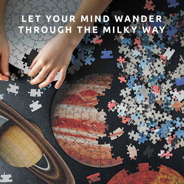 Childs Hands assembling Pikkii's Jigsaw Planets with message Let Your Mind Wander Through the Milky Way over desk