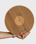 Hand holding a 12" Inch vinyl record shaped bamboo wooden Chopping Board