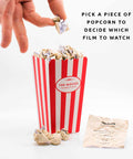 Movie Popcorn Bucket List with hand picking a scrunched paper popcorn piece