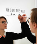 Woman writing her fitness goals on a mirror